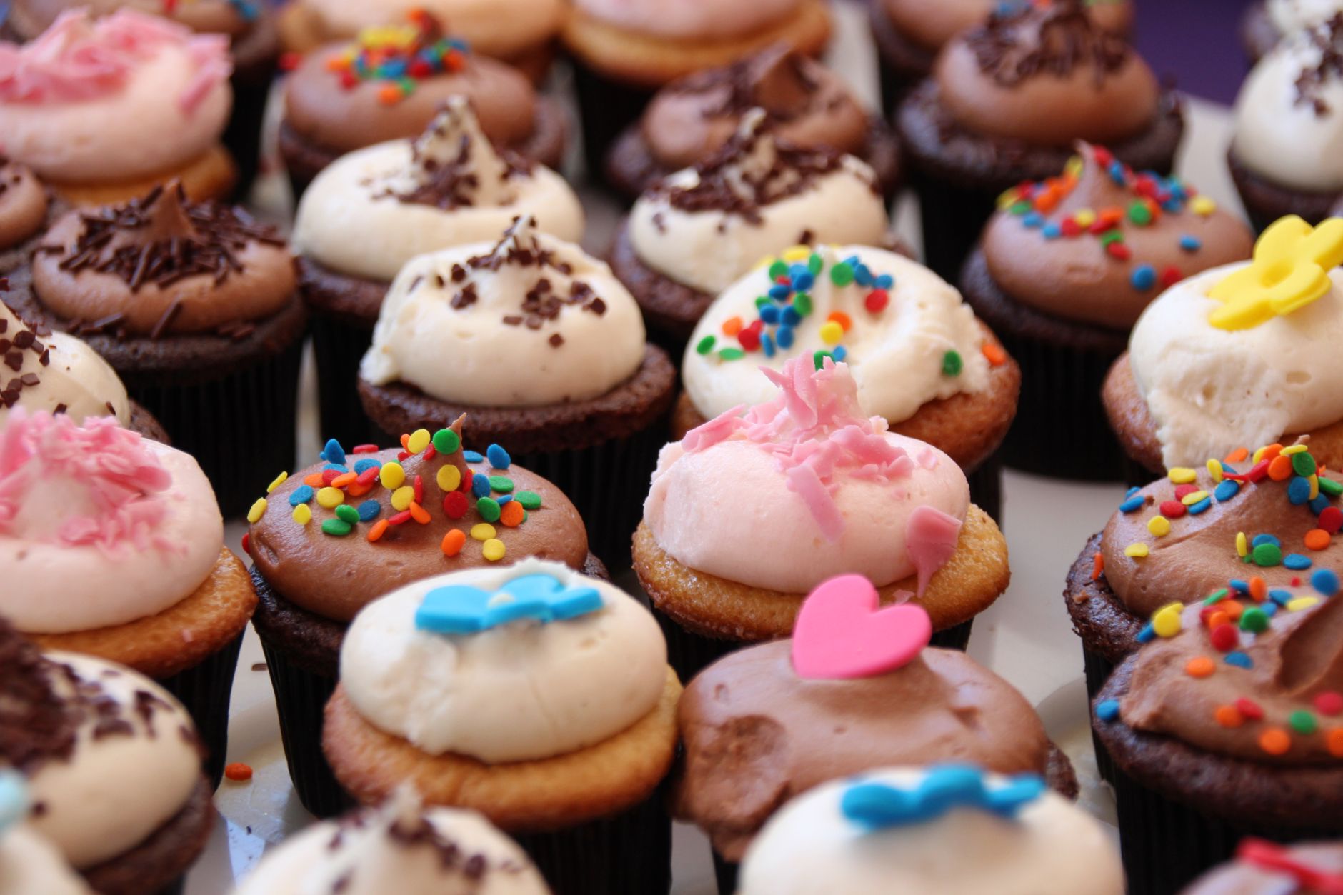 Close-up view of colorful decorated cupcakes with sprinkles and frosting.