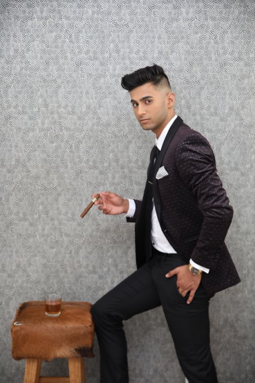 Free Stylish man in a black suit holding a cigar, showcasing elegance. Stock Photo