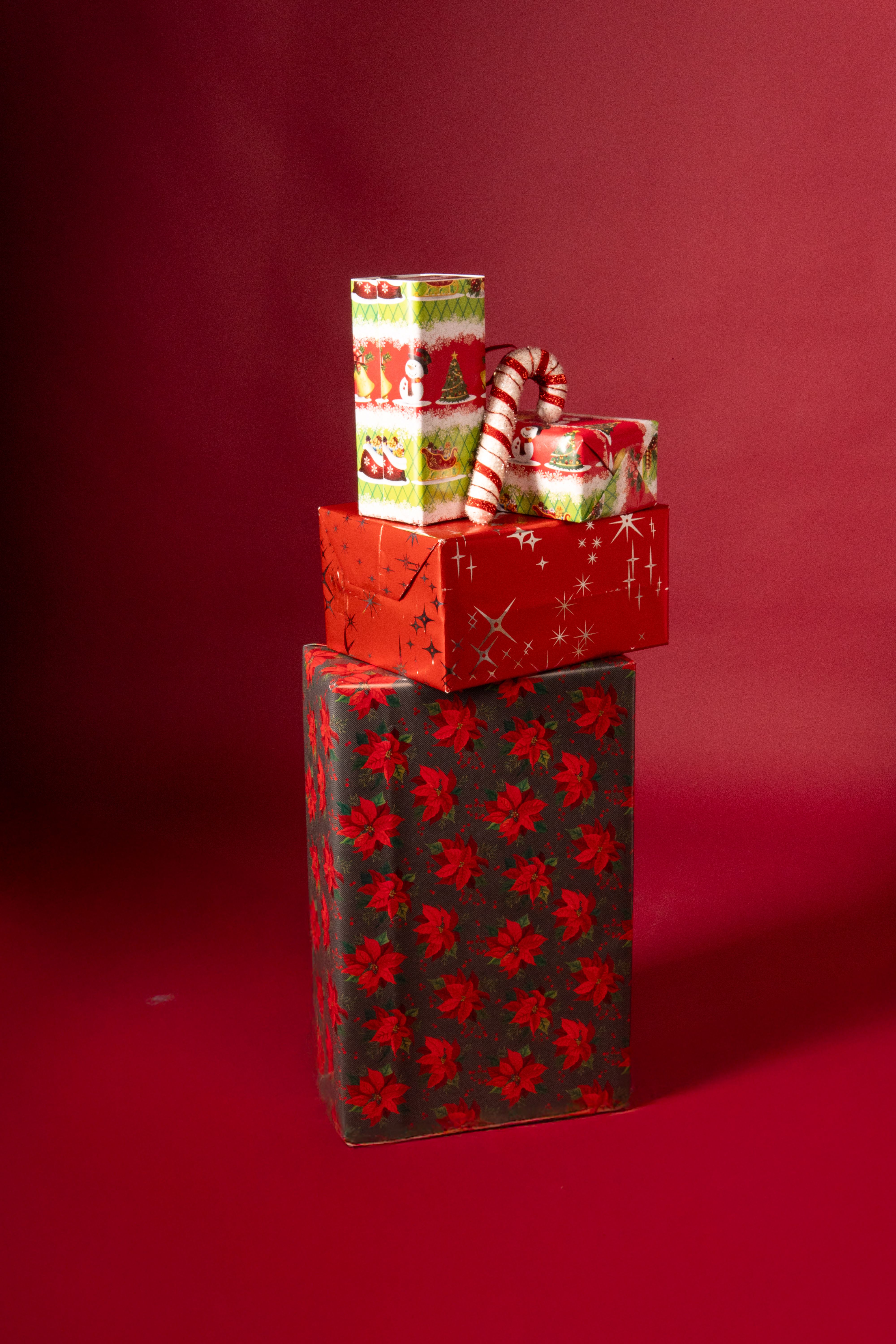 Stack of colorful gift boxes on a red background, perfect for holiday celebrations.