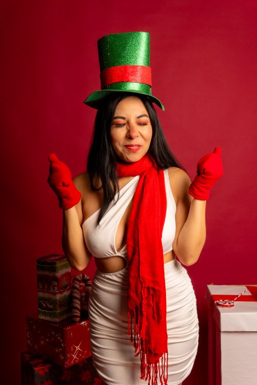 Free A joyful woman in festive attire celebrating Christmas with gift boxes and holiday decorations. Stock Photo