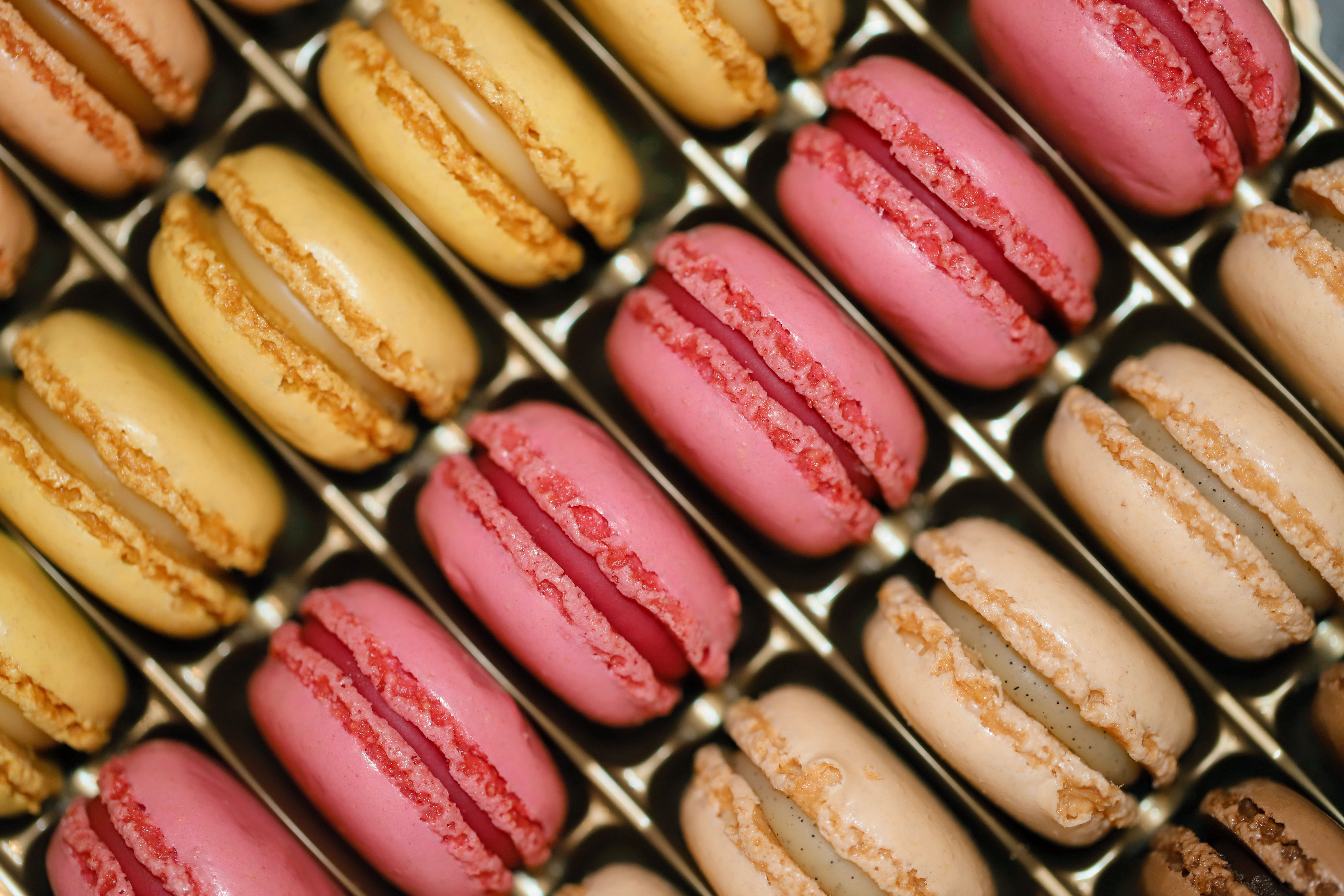 Close-up of assorted colorful French macarons in a box, showcasing vibrant gourmet pastries.