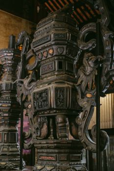 Close-up of a detailed historical artifact showcasing traditional Vietnamese craftsmanship inside a temple.