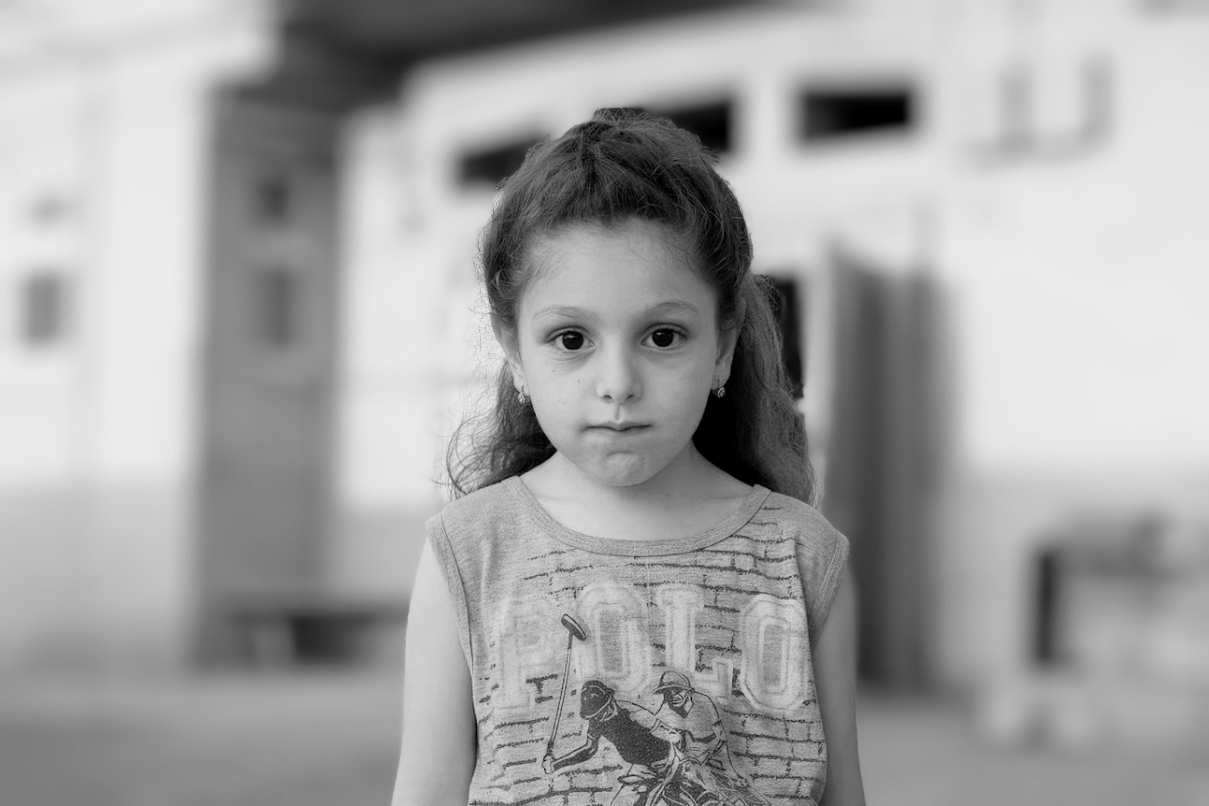 Free A thoughtful black and white portrait of a young girl looking directly at the camera. Stock Photo