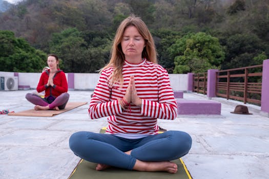 Two women meditating outdoors in a peaceful yoga session.
