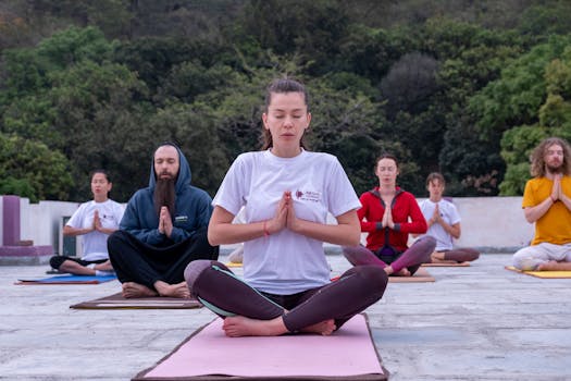 A diverse group practicing meditation outdoors in a serene environment.