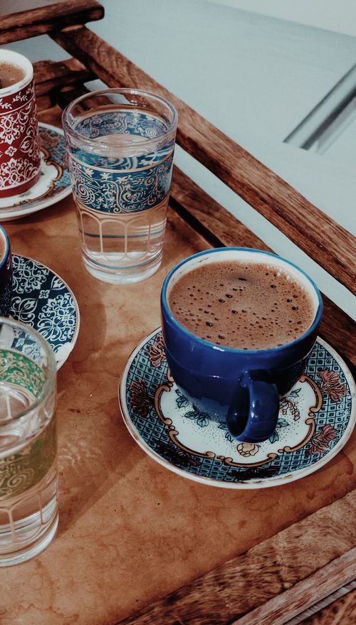 Free Stylish coffee cups on a wooden tray with intricate patterns and vibrant colors. Stock Photo
