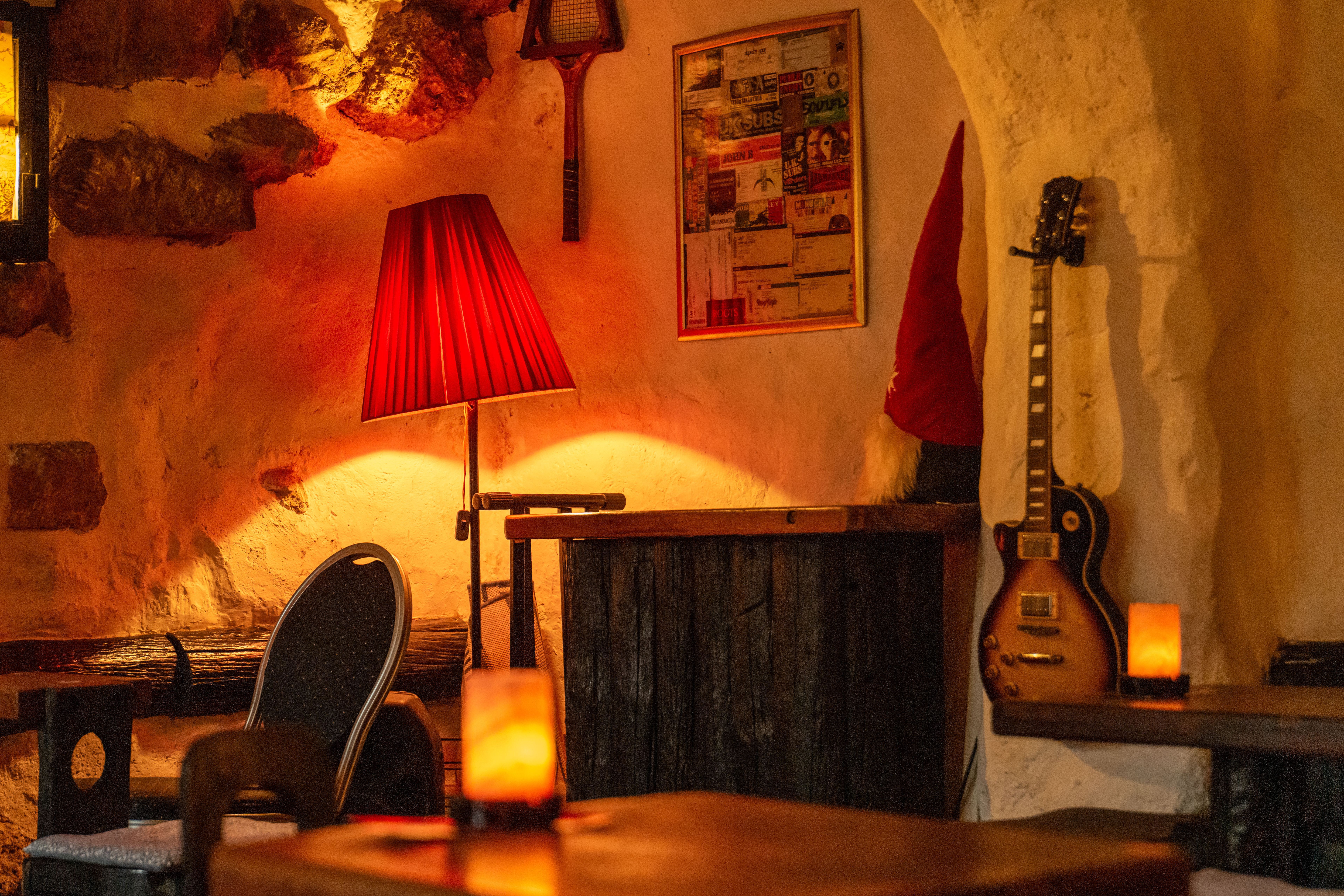 Warm, cozy bar interior featuring vintage decor, warm lighting, and a guitar in Zagreb.