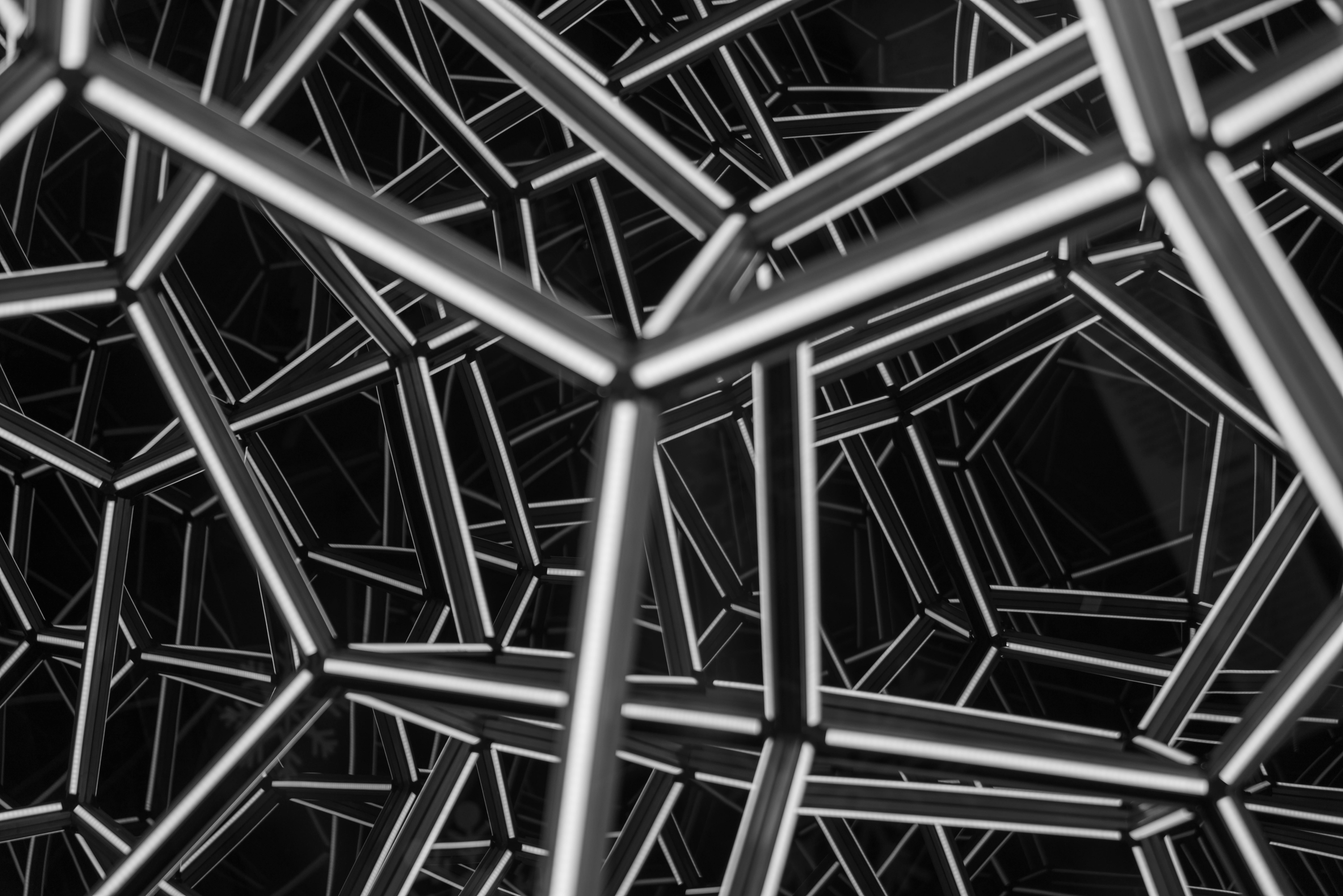 Black and white geometric pattern with intersecting lines, creating an abstract and complex visual effect.