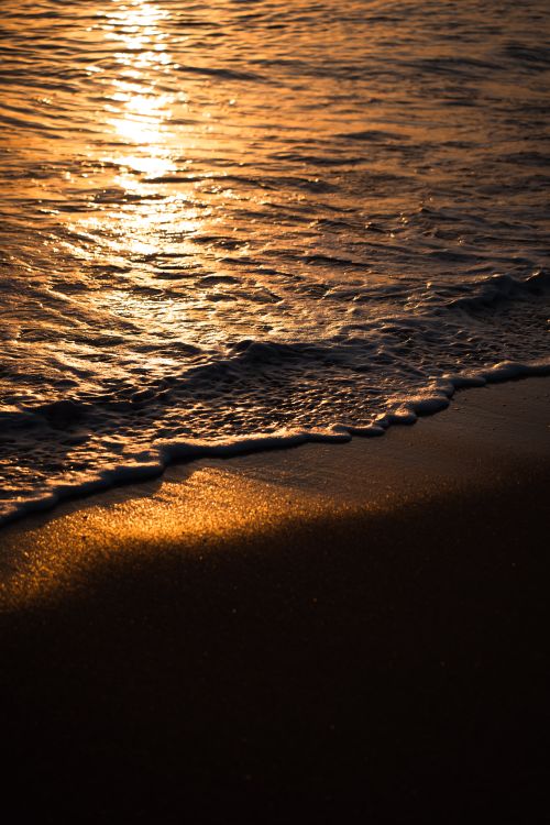 Free Beautiful sunset reflecting on Antalya beach waves and shore, showcasing vibrant colors. Stock Photo