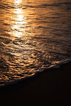Captivating view of golden sunset reflecting on the waves at Antalya beach, Turkey.