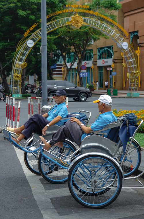 Free Street scene featuring traditional cyclo riders in vibrant Việt Nam setting. Stock Photo