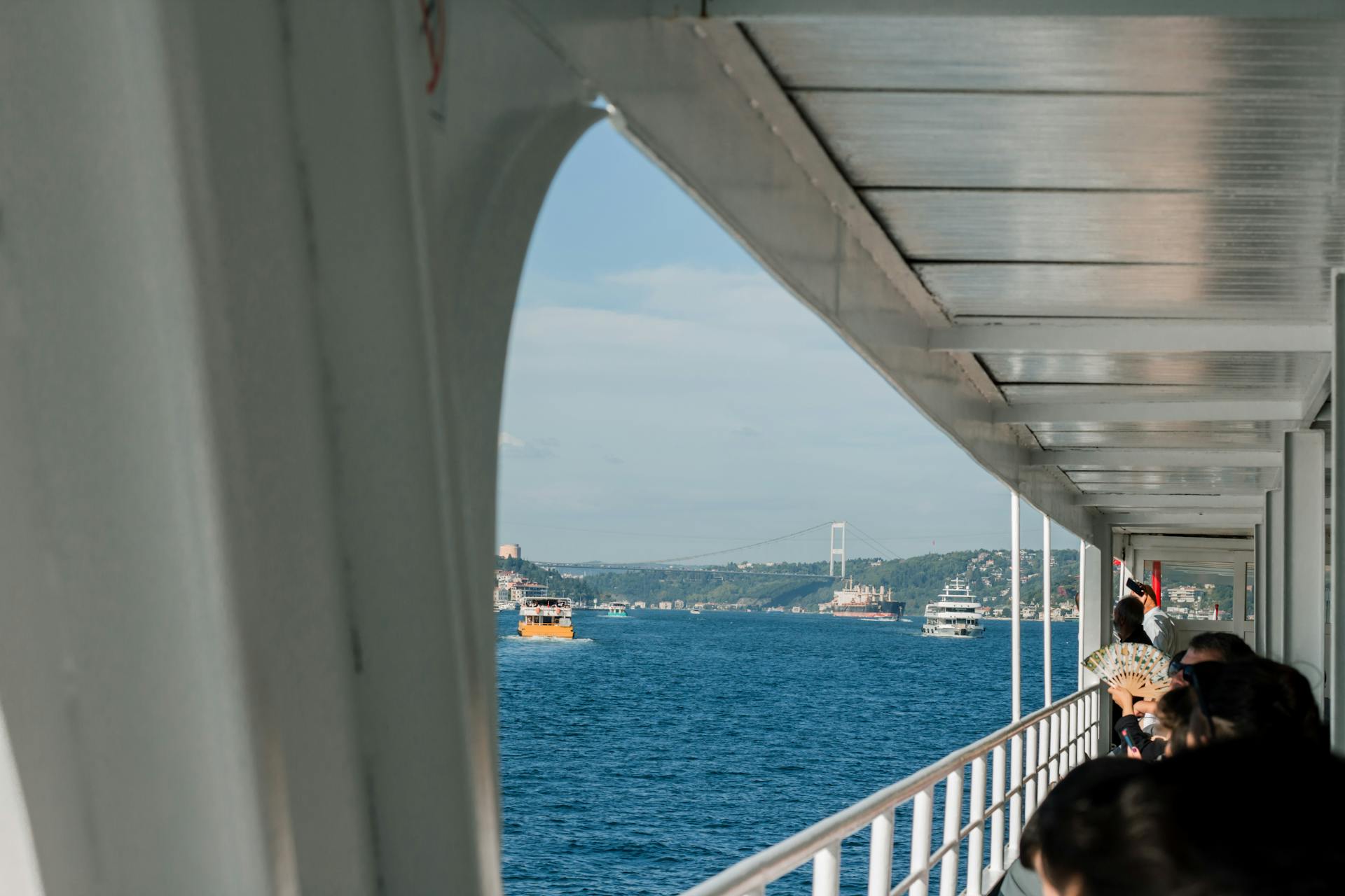 Passengers enjoy a ferry ride with views of the Bosphorus Bridge in Istanbul.
