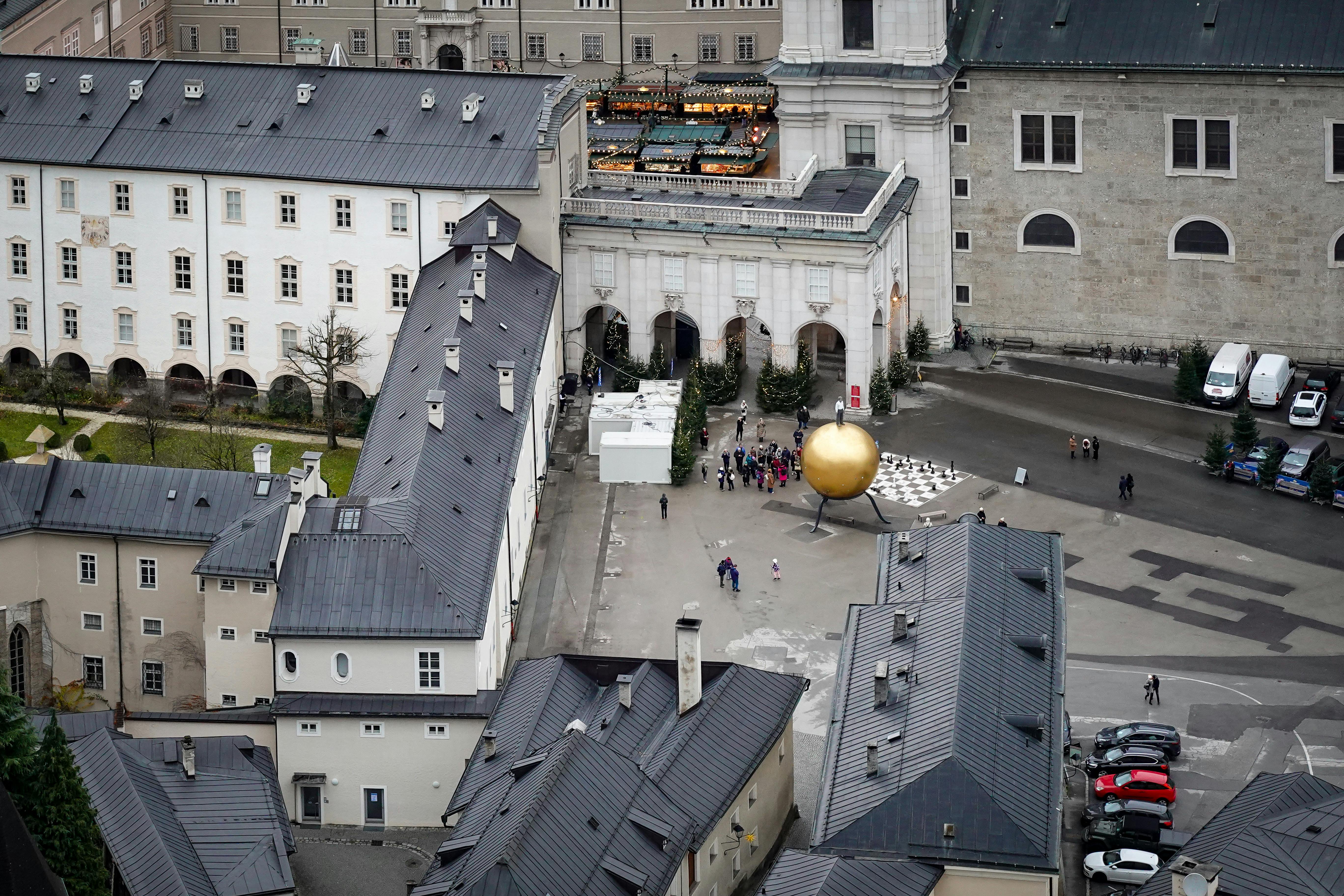 Aerial view of Salzburg's old town featuring the iconic golden orb sculpture.