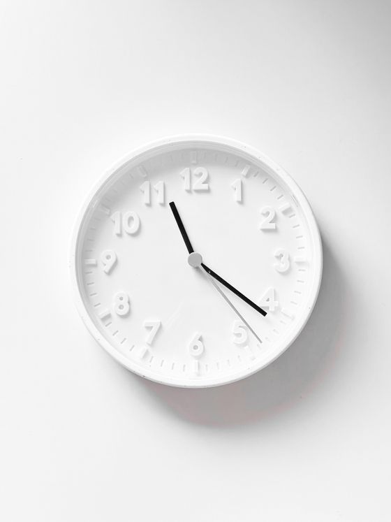 Plain white wall clock on a pale wall — photo by Ruxanda Photography on Pexels
