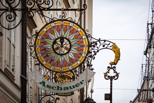 Free Ornate vintage metal shop sign with stained glass on a European street. Stock Photo