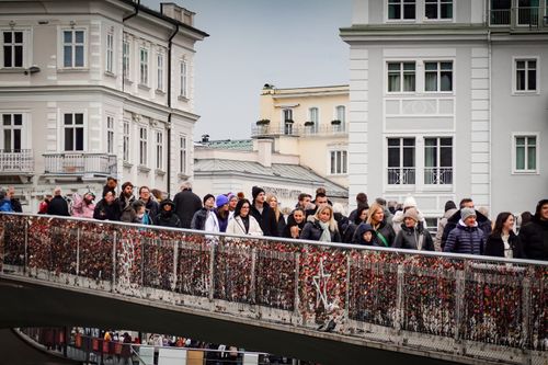 Free Group of people walking on a love lock bridge in a cityscape. Stock Photo