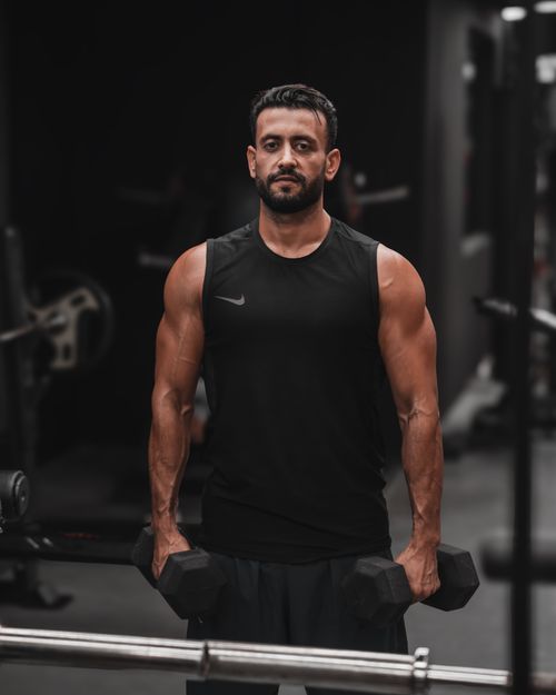 Free Focused adult male lifting dumbbells in a gym, showcasing strength and fitness. Stock Photo