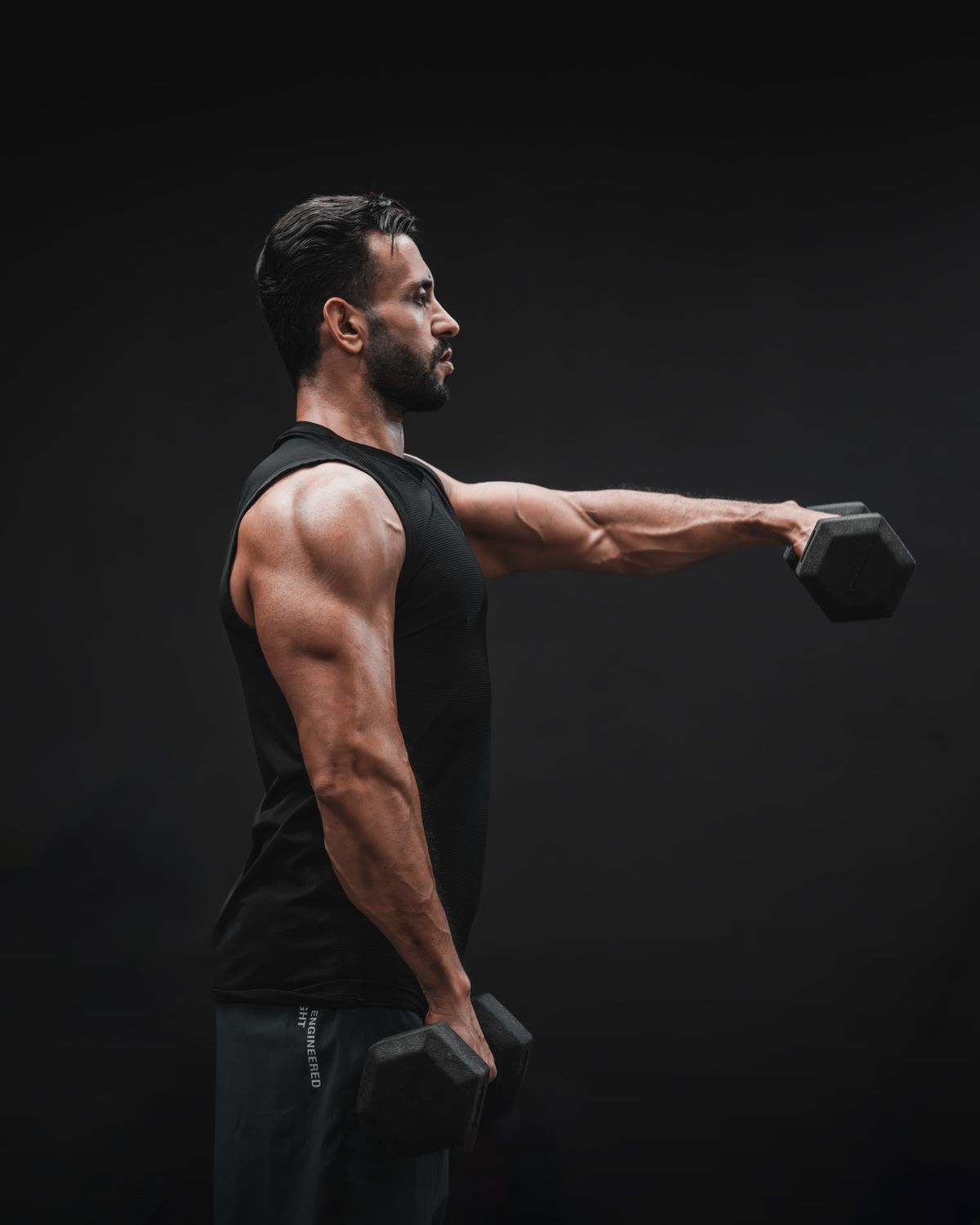 The best shoulder workout for bigger, stronger delts | the gym pro Focused Man Performing A Dumbbell Shoulder Press In A Gym