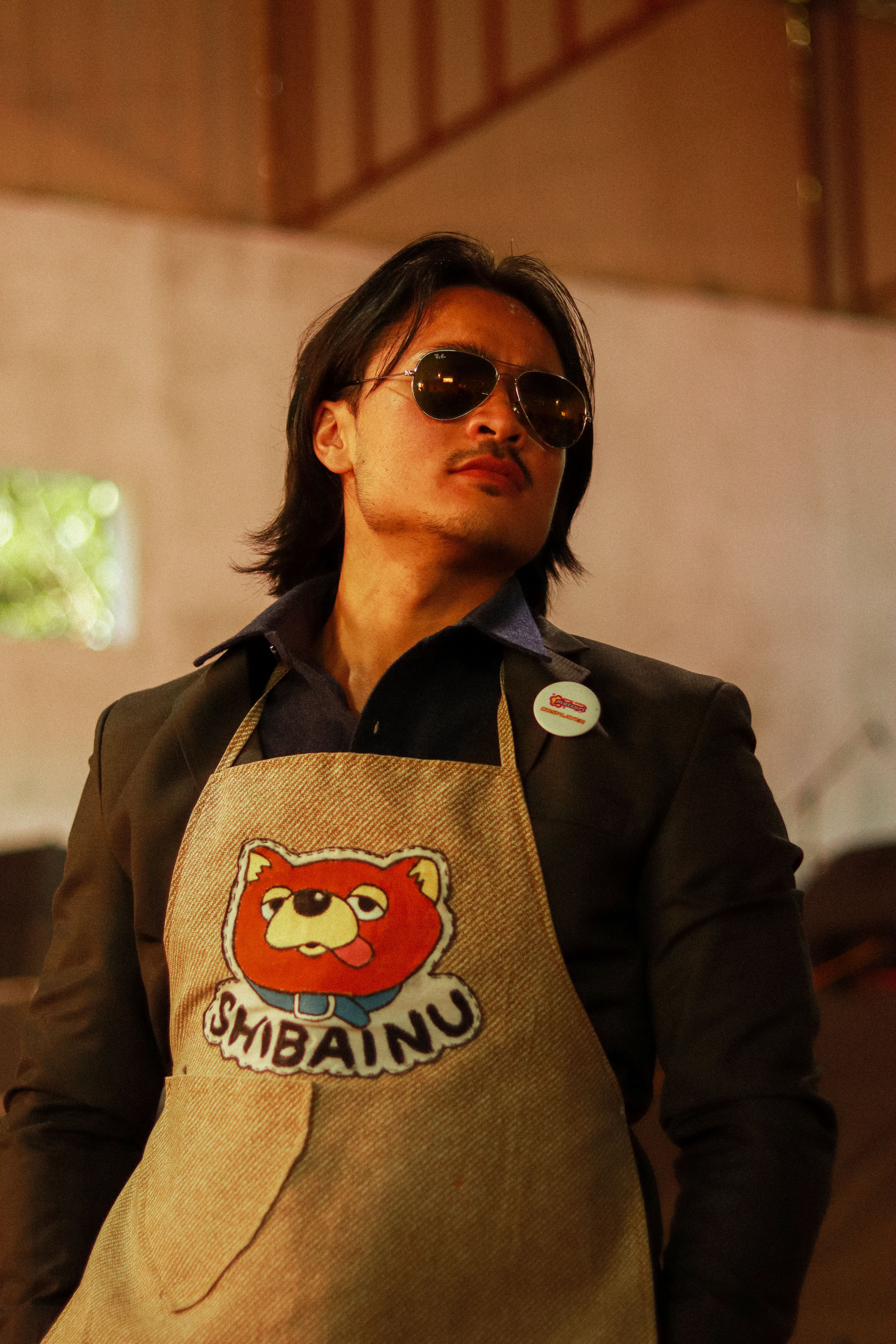 Portrait of a stylish individual in a Shiba Inu apron, exuding confidence.