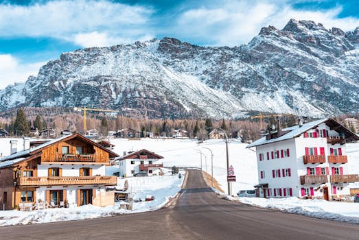 Charming Alpine houses with snowy mountains in Cortina d'Ampezzo, Italy.