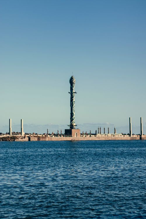 Free A majestic sculpture by the sea with a clear blue sky above. Stock Photo