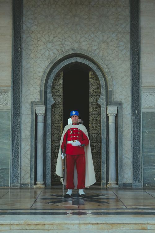 Free Royal guard standing at historic mausoleum entrance in Rabat, Morocco, showcasing traditional attire. Stock Photo
