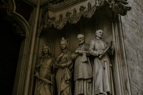 Free Intricate Gothic stone statues adorn the cathedral's exterior facade. Stock Photo