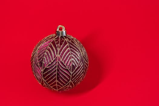 A single decorative Christmas ornament with gold patterns on a vibrant red background.