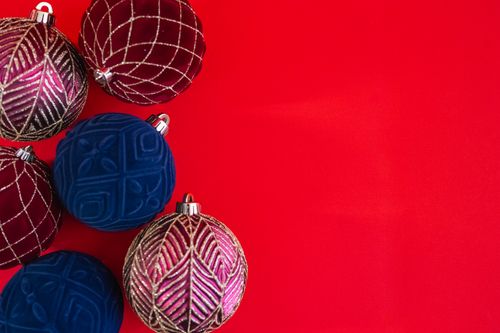 Free Festive Christmas ornaments with rich patterns on a vibrant red background. Ideal for holiday themes. Stock Photo