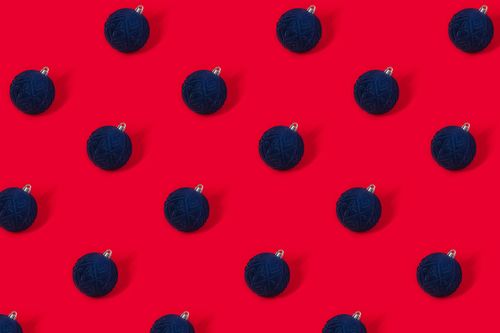 Free Stylish blue Christmas ornaments arranged on vivid red backdrop. Perfect for holiday design. Stock Photo