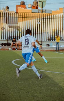 Back view of soccer player on an urban outdoor field during a match.