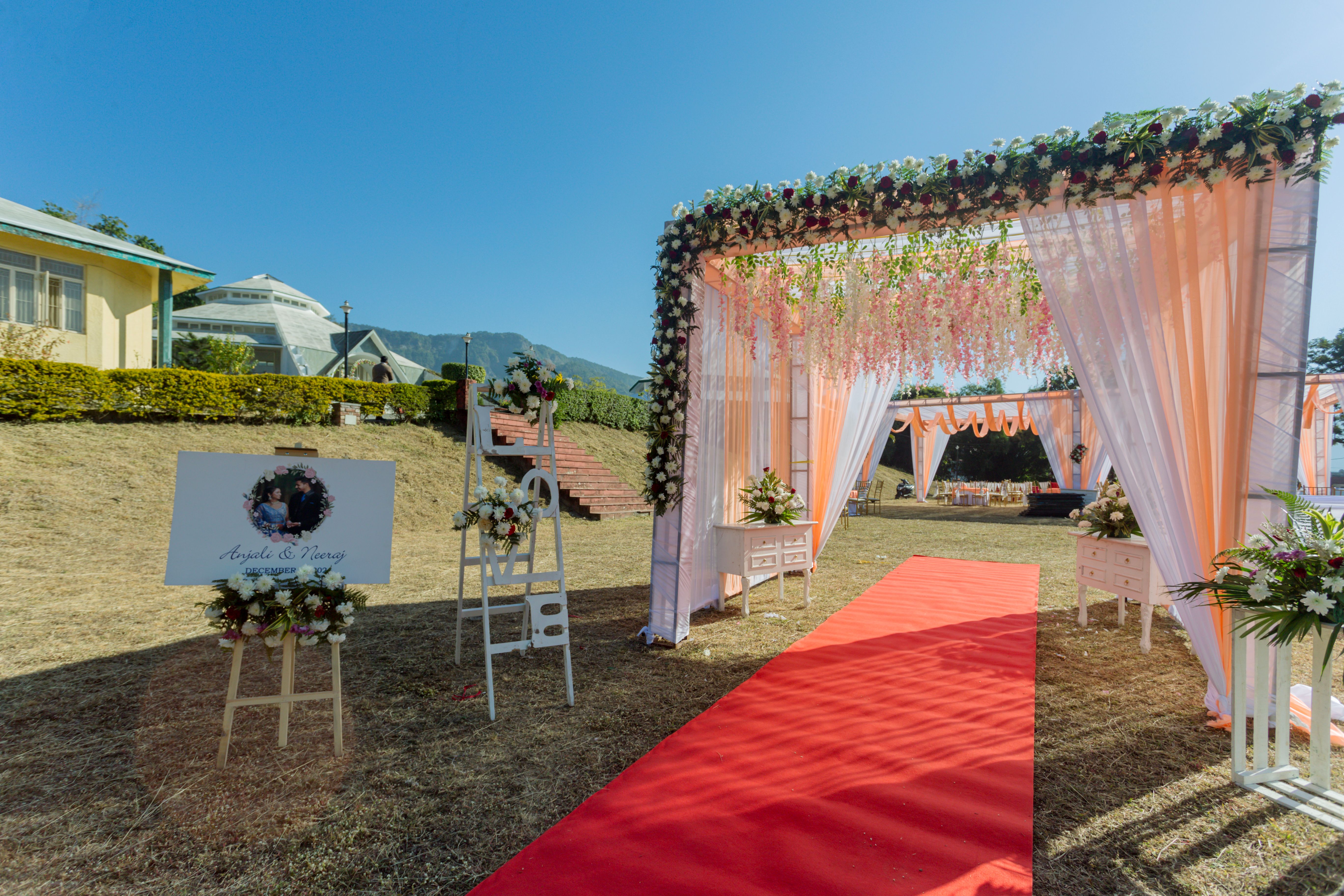Beautiful outdoor wedding setup with floral decorations and a red carpet path.