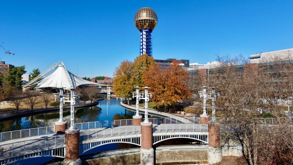 A vibrant aerial view of the iconic Sunsphere amidst fall foliage in Knoxville, Tennessee.