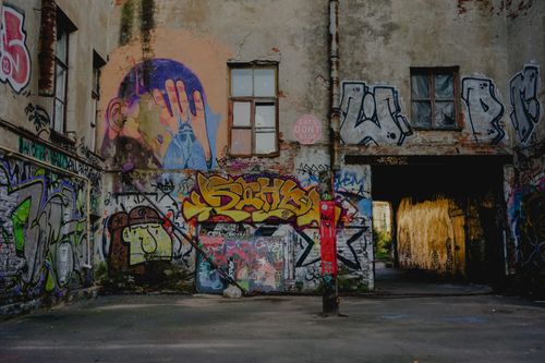 Free Vibrant street art and graffiti cover abandoned urban building walls, showcasing creative expression. Stock Photo