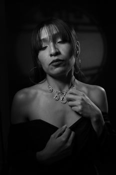 Artistic black and white portrait of a woman wearing jewelry, evoking classic elegance.