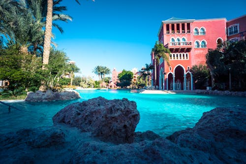 Swimming Pool Near Pink Concrete Structure