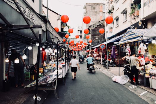 Captivating street market scene adorned with red lanterns, bustling with people and vendors at twilight.