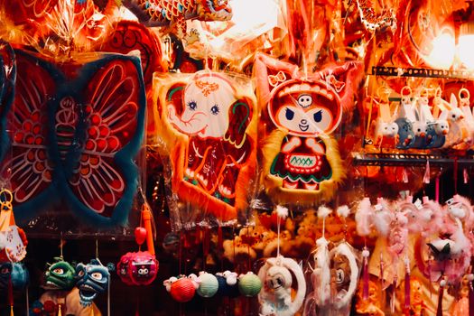 Vibrant display of traditional paper decorations in an outdoor market setting.