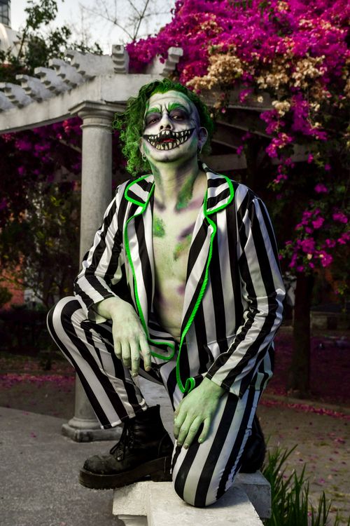 Free Creative cosplay portrait with striped suit and floral backdrop, showcasing artistry. Stock Photo