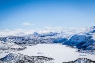 蔚蓝的天空下，白雪覆盖的山脉与冰冻的湖泊构成了一幅令人惊叹的冬季全景