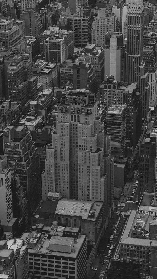 Free Black and white aerial shot of New York City's iconic skyline featuring the New Yorker Hotel. Stock Photo