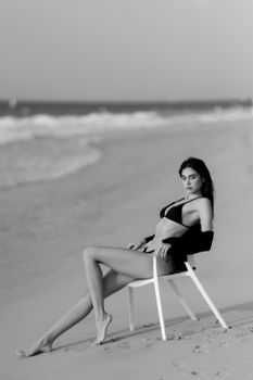 Stylish black and white portrait of a woman relaxing on a Dubai beach.