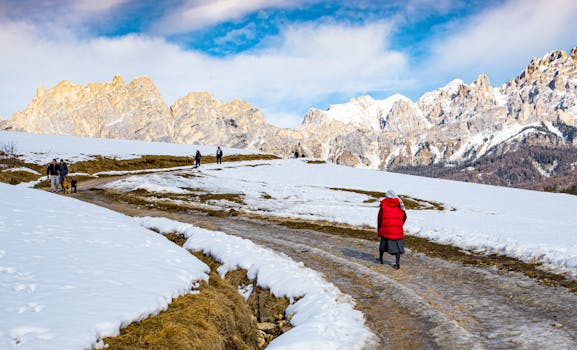 Hikers enjoy a winter walk in Cortina d'Ampezzo with the Dolomites as backdrop.