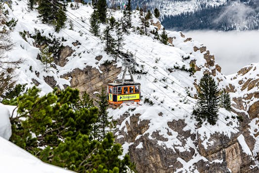 Cable car navigating snowy cliffs in Cortina d'Ampezzo, Italy during winter.