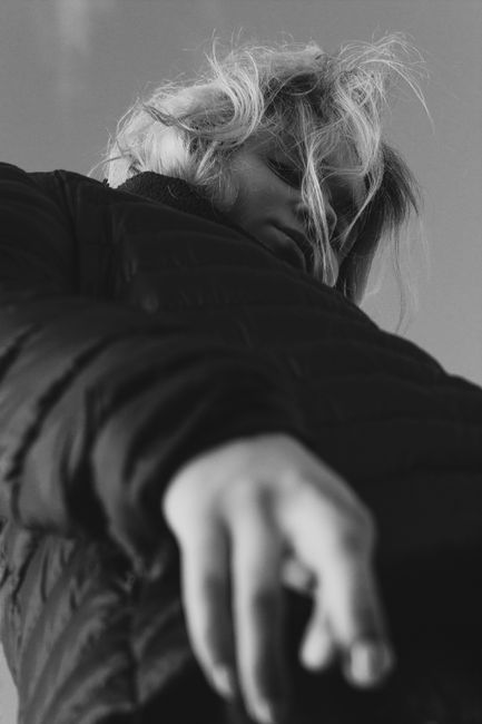 Unique grayscale portrait capturing a woman from below in an outdoor setting.
