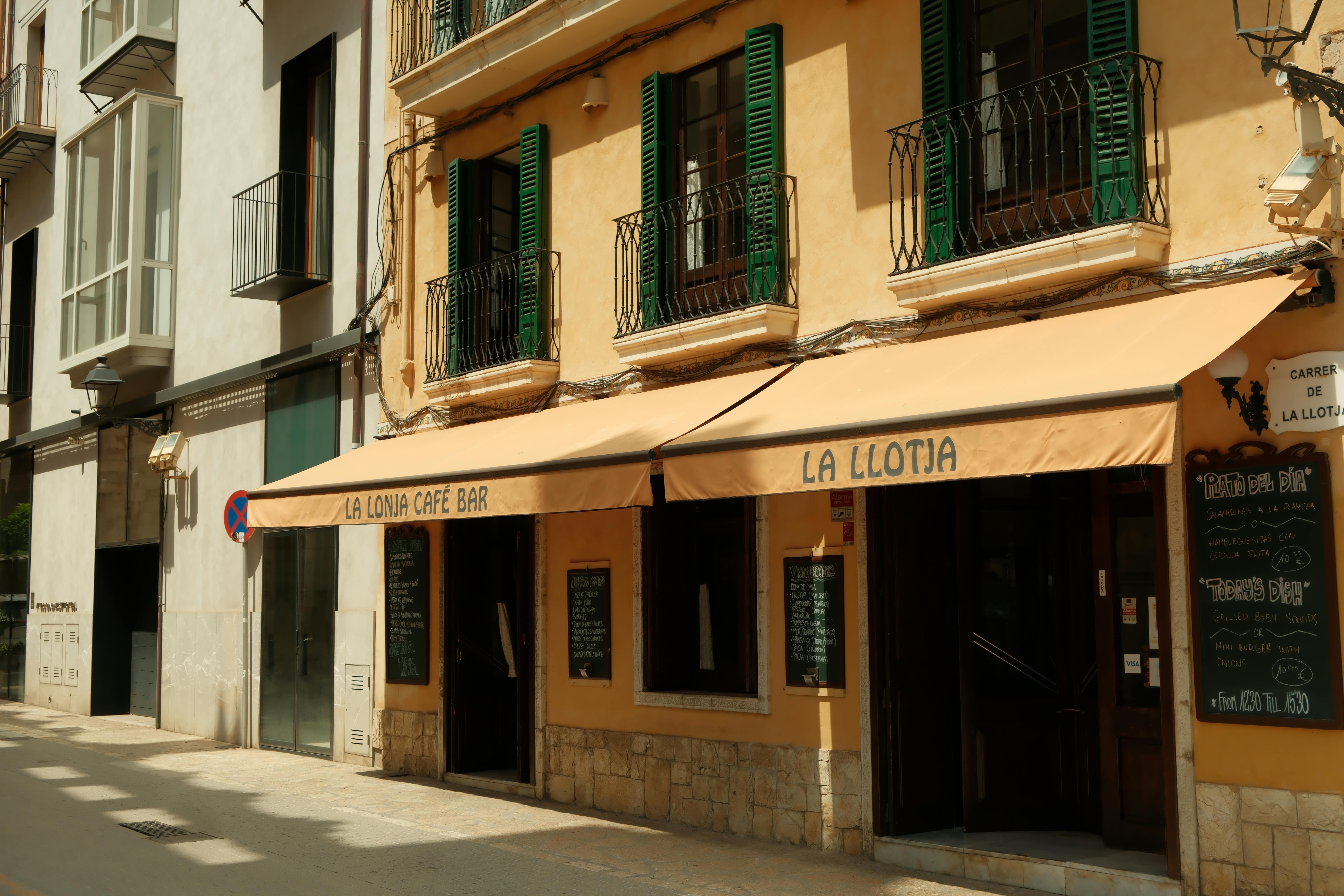 Free Explore the charming La Llotja Café in the sunlit streets of the Balearic Islands, Spain. Stock Photo