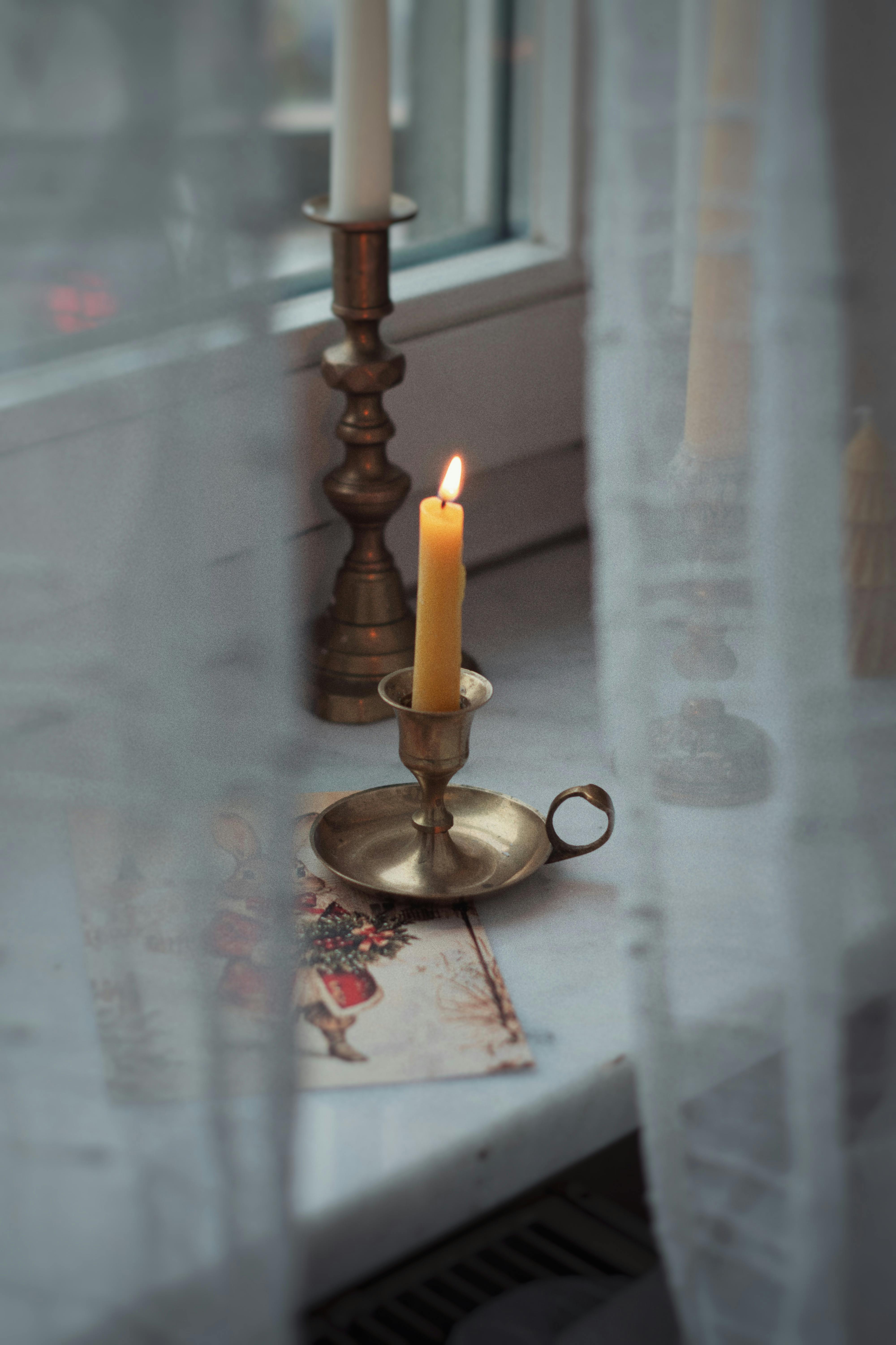 Warm and inviting candlelit scene on a windowsill, perfect for winter coziness.