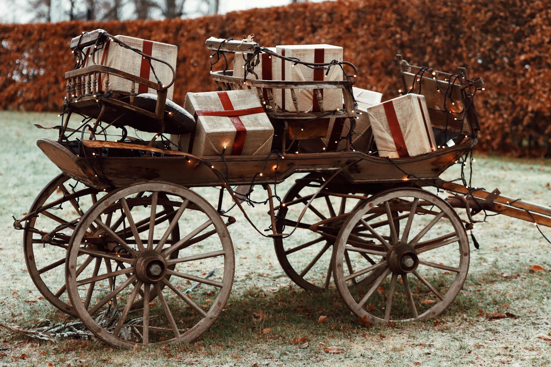Wooden cart filled with wrapped Christmas gifts and lights, set in a frosty outdoor landscape in Jönköping, Sweden.
