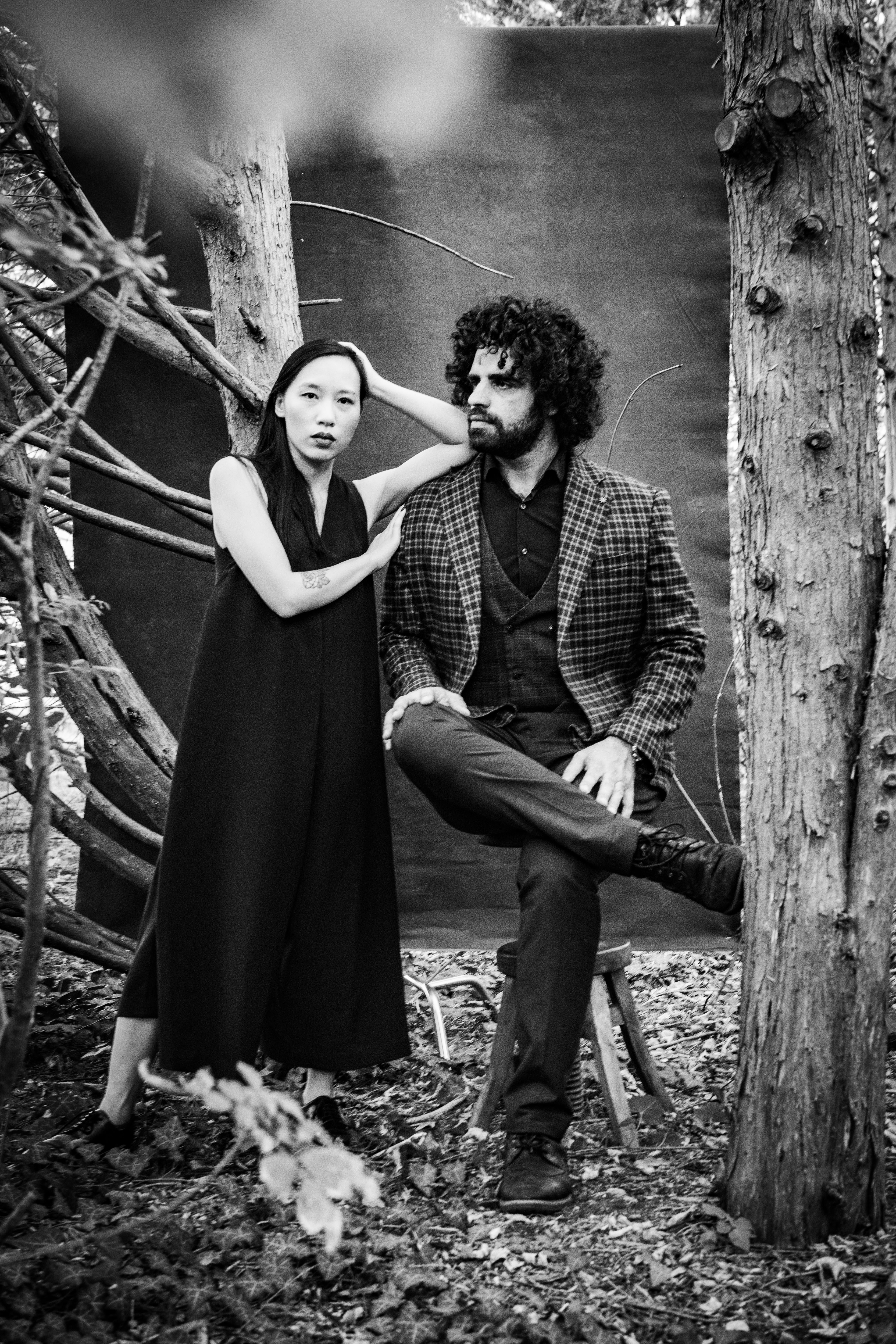 Stylish black and white portrait of a couple in an outdoor artistic setting.