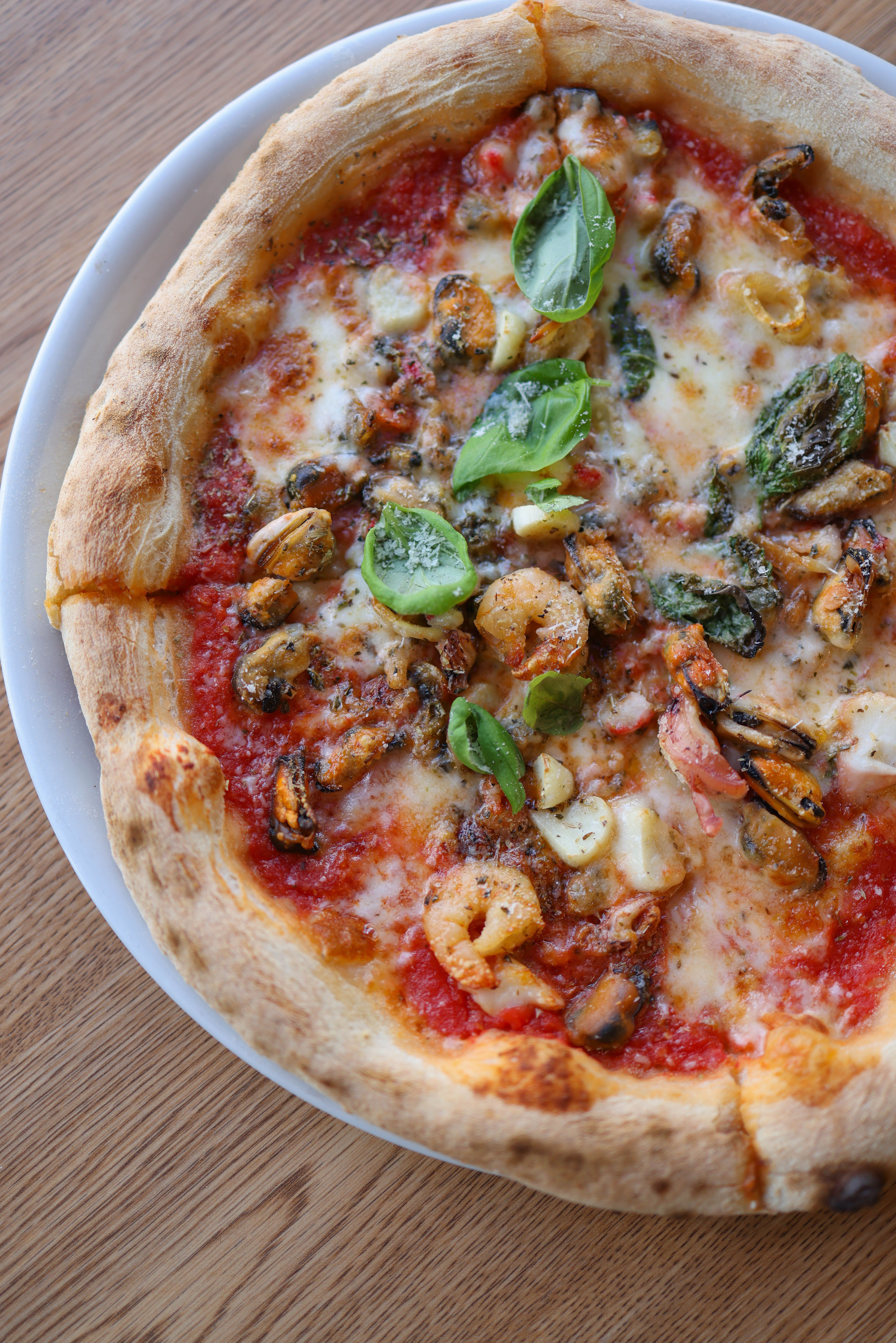 Gourmet Seafood Pizza with Fresh Basil · Free Stock Photo